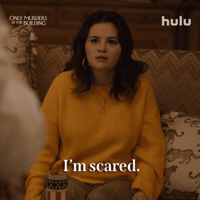 Woman In Yellow Sweater Sitting On Couch GIF