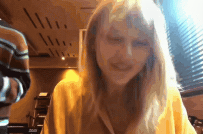 Woman In Yellow Sweater Smiling At Camera GIF