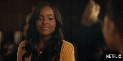 Woman In Yellow Sweater Smiling In Front Of Netflix Logo GIF