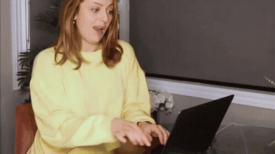 Woman In Yellow Sweater Using Laptop GIF