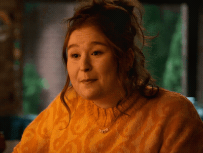 Woman In Yellow Sweater With Butterfly Necklace GIF