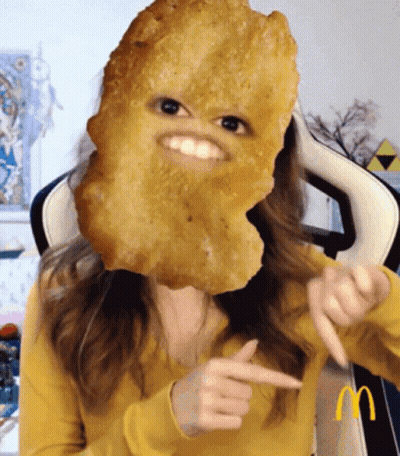 Woman In Yellow Sweater With Chicken Nugget On Face GIF
