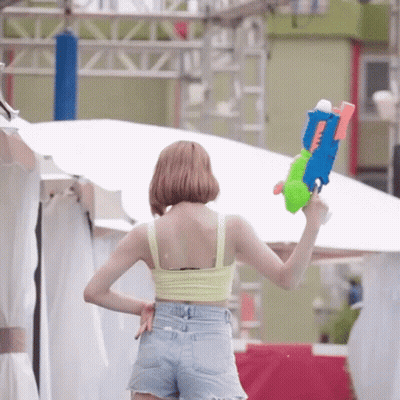 Woman In Yellow Tank Top Holding Water Gun GIF