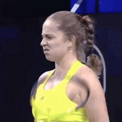 Woman In Yellow Tank Top Making Funny Face With Tennis Racquet GIF