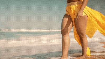 Woman In Yellow Top And Shorts On Beach GIF