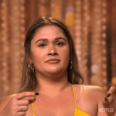 Woman In Yellow Top Pointing At Netflix Logo GIF