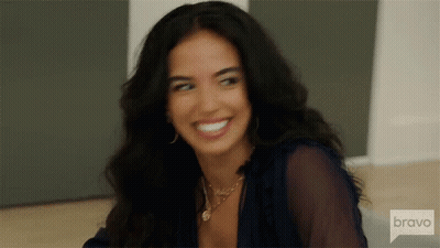 Woman In Yellow Top Sitting In Chair Saying Bravo GIF