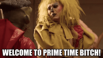 Woman In Yellow Wig Next To Man Saying Welcome To Prime Time Bitch GIF