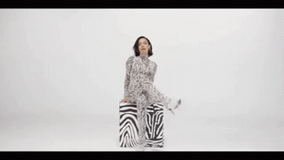 Woman In Zebra Print Jumpsuit Sitting GIF