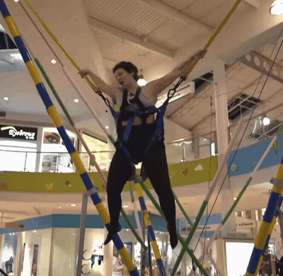 Woman Jumping On Trampoline In Mall With Abercrombie Sign GIF