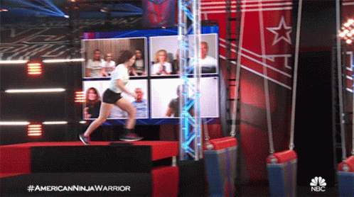 Woman Jumping Over Barrier In Front Of NBC Screen GIF