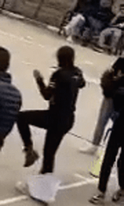 Woman Kicking Man In Front Of Group GIF