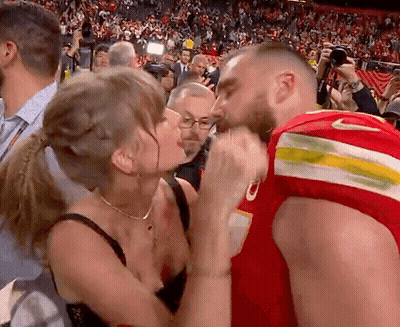 Woman Kissing Man In Red Jersey With Letter O GIF