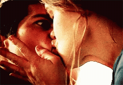 Woman Kissing Man On Cheek As He Covers Mouth GIF