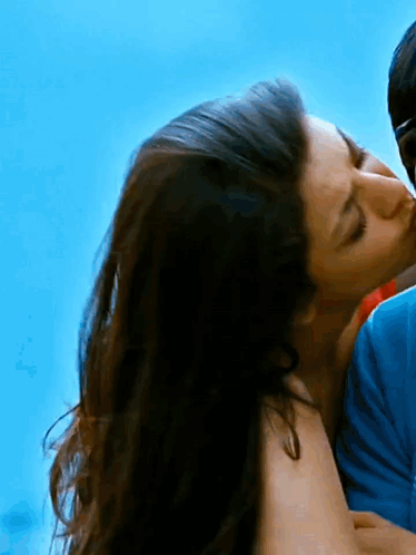 Woman Kissing Man on Cheek Blue Sky