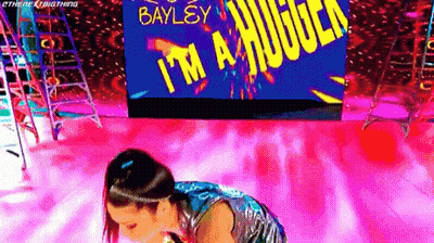 Woman Kneeling In Front Of Screen Saying Bayley I'm A Huge GIF