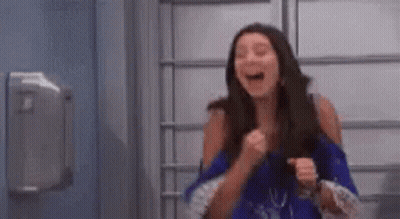 Woman Laughing And Holding Fist In Air GIF