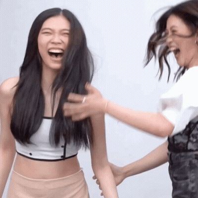 Woman Laughing As Another Holds Arm GIF