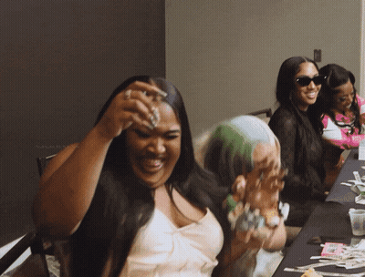 Woman Laughing At Table With Money GIF