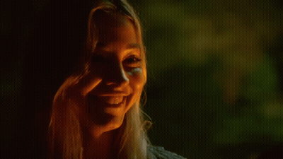 Woman Laughing Holding Beer In Dark Room GIF