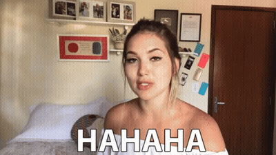 Woman Laughing In Bedroom With Hahaha On Wall GIF