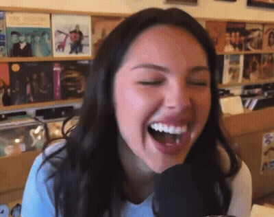 Woman Laughing Into Microphone In Store GIF