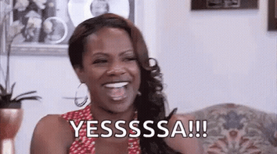 Woman Laughing On Couch Saying Yesssss GIF
