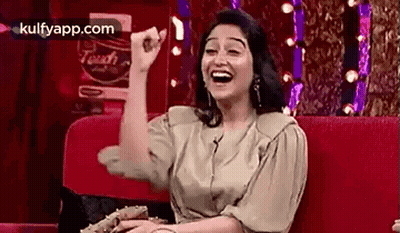 Woman Laughing On Red Couch GIF