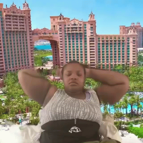 Woman Laying Down in Front of Building With Palm Trees