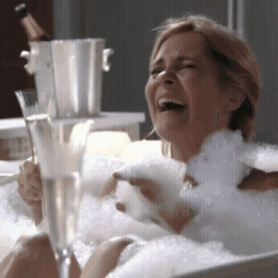 Woman Laying In Bathtub Holding Wine GIF