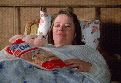 Woman Laying In Bed Holding Cheez Crisps GIF