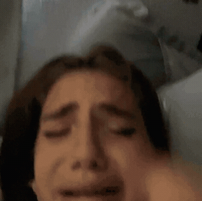 Woman Laying In Bed With Hand On Head GIF