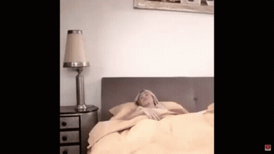 Woman Laying In Bed With Lamp And Nightstand GIF