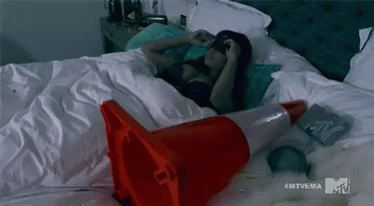 Woman Laying In Bed With Red Traffic Cone GIF