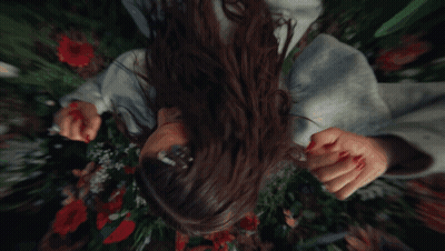 Woman Laying In Flowers Man Holding Her Hand GIF