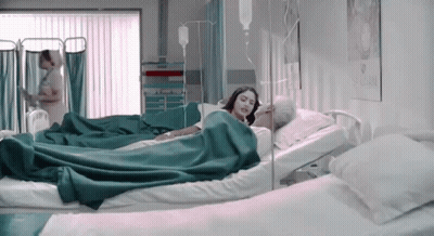 Woman Laying In Hospital Bed Next To Older Man With IV GIF