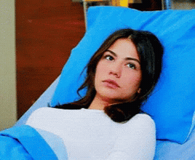 Woman Laying In Hospital Bed With Blue Pillows GIF