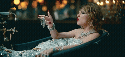 Woman Laying In Ice-Filled Bathtub Holding Necklace GIF