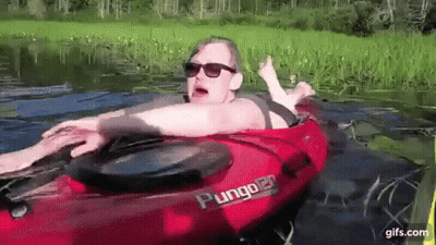 Woman Laying In Red Plunger Kayak In Lake GIF