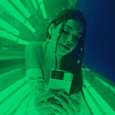 Woman Laying In Tanning Bed With Green Lights GIF