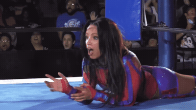 Woman Laying In Wrestling Ring With Hands Outstretched GIF