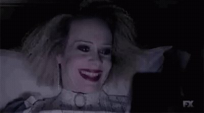 Woman Laying On Bed Looking At Cell Phone In Dark GIF