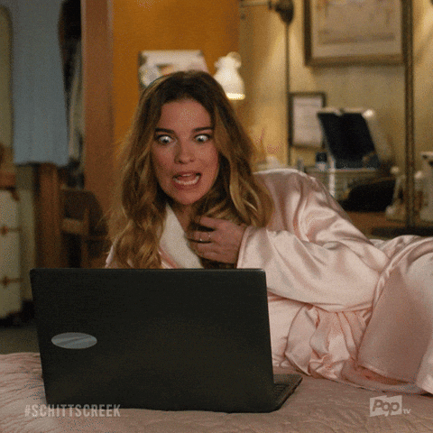 Woman Laying On Bed Looking At Laptop With Schittscreek GIF