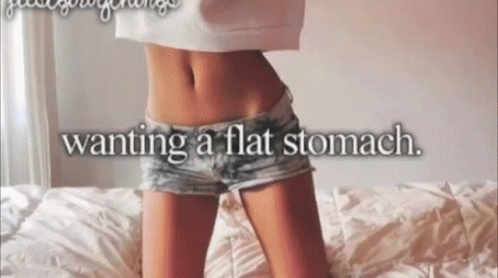 Woman Laying On Bed Wanting Flat Stomach GIF