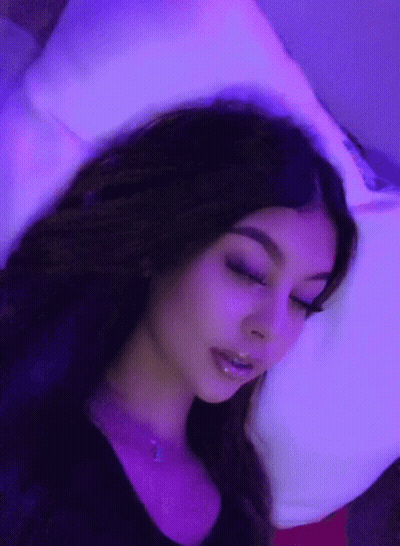 Woman Laying On Bed With Purple Lights GIF