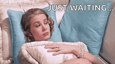Woman Laying On Bed With Ring Saying Just Waiting GIF