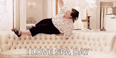 Woman Laying On Couch Arms Up Saying I Love Spa Day GIF