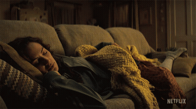 Woman Laying On Couch With Blanket And Netflix Logo GIF