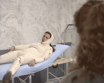 Woman Laying On Hospital Bed With Head Bandage GIF
