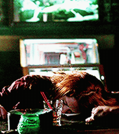 Woman Laying on Table With Drink in Front of Jukebox